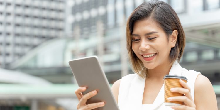 Successful beautiful  asian business  young woman using smart phone and coffee cup in hand , business concept