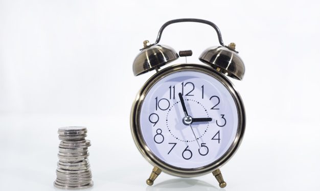 TIME IS MONEY concept: Alarm clock and with coins