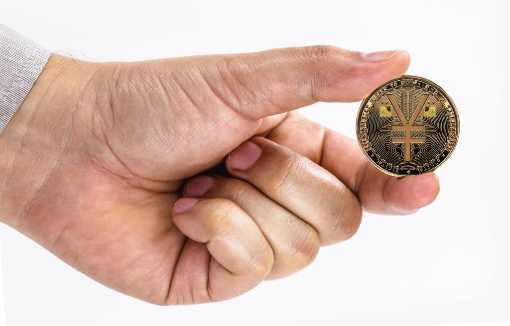 male hand holding e-RMB coin on isolated white background with space copy, china virtual money concept.